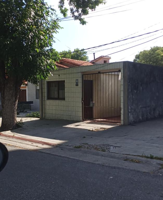 een klein geel huis met een hek ervoor bij Los Tilos in Colonia del Sacramento