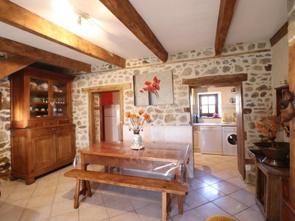 a kitchen with a wooden table with flowers on it at Gîte Sansac-Veinazès, 3 pièces, 4 personnes - FR-1-742-114 