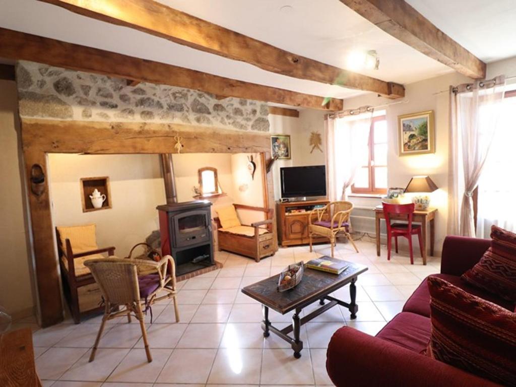 a living room with a couch and a stove at Gîte Sansac-Veinazès, 3 pièces, 4 personnes - FR-1-742-114 