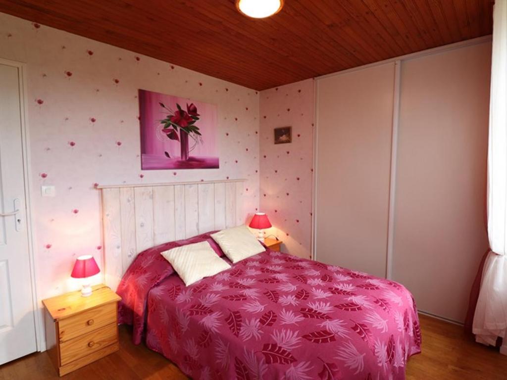 a bedroom with a bed with a pink blanket and two lamps at Gîte Sansac-Veinazès, 3 pièces, 4 personnes - FR-1-742-114 