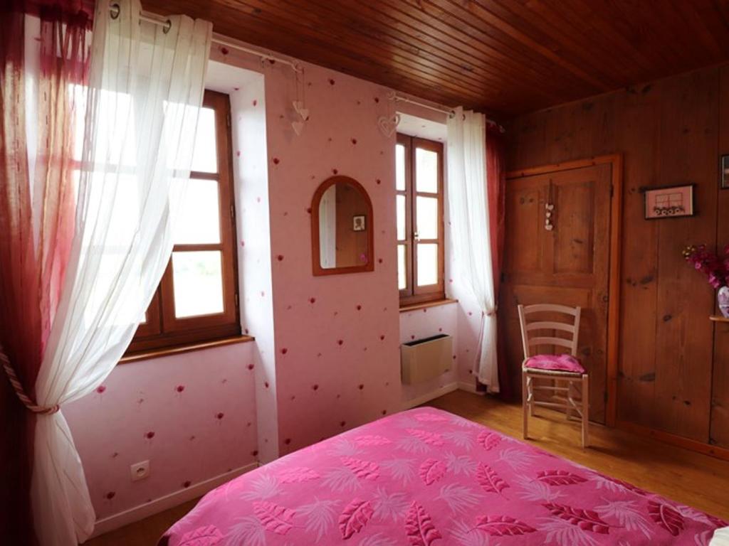 a bedroom with a pink bed and a window at Gîte Sansac-Veinazès, 3 pièces, 4 personnes - FR-1-742-114 
