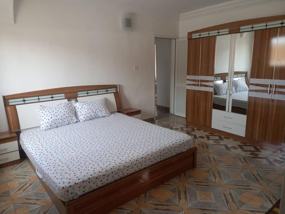 sypialnia z łóżkiem i dużym lustrem w obiekcie RESIDENCE YATOO w mieście Nawakszut