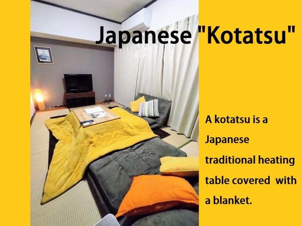 um quarto com uma cama com um cobertor amarelo em 板橋 RCアネックス Rc306 em Tóquio