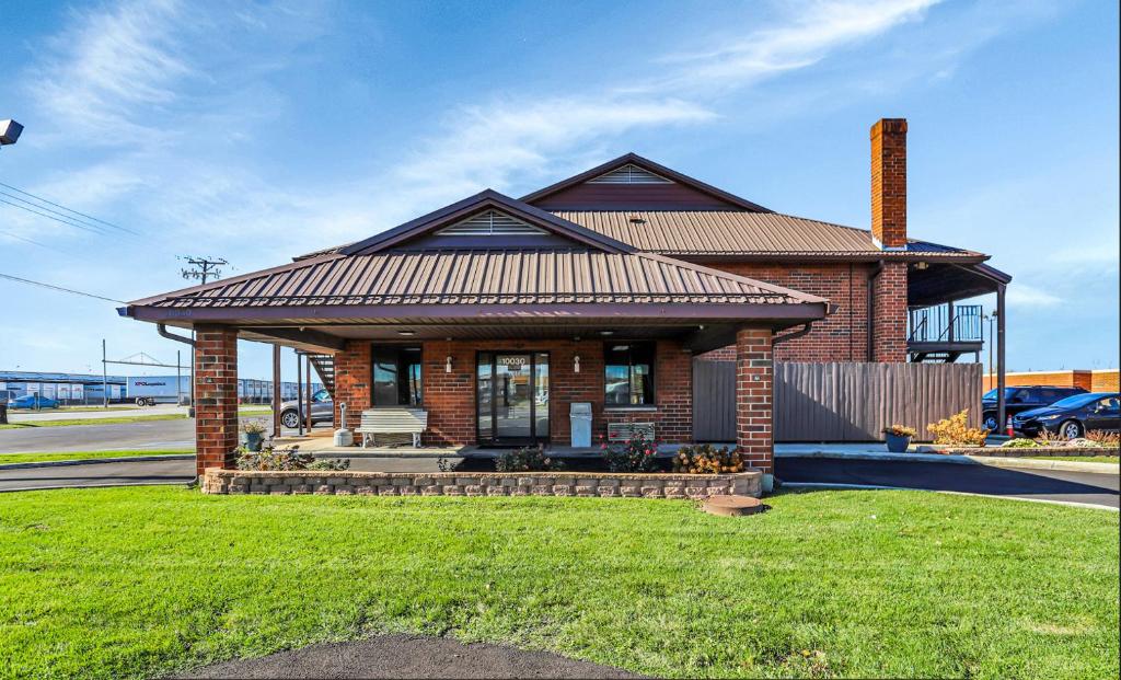 a small brick house with a roof on a lawn at Bridgeview Inn Chicago Area in Bridgeview