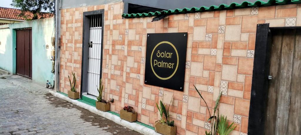 un panneau sur le côté d'un bâtiment en briques dans l'établissement Solar palmer 6, à Cabo Frio