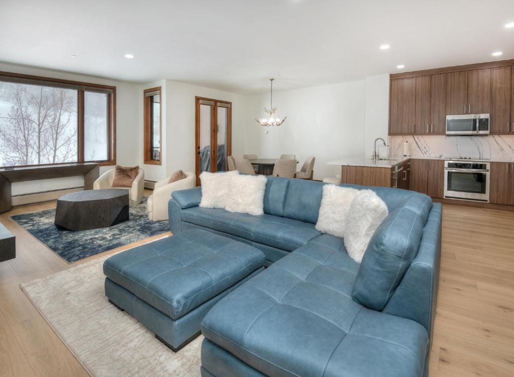 a living room with a blue couch and a kitchen at Highlands Slopeside #221 condo in Beaver Creek