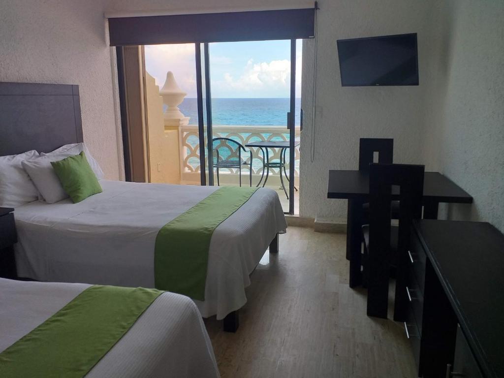 a hotel room with two beds and a view of the ocean at “Magic Sunrise at Cancun” in Cancún