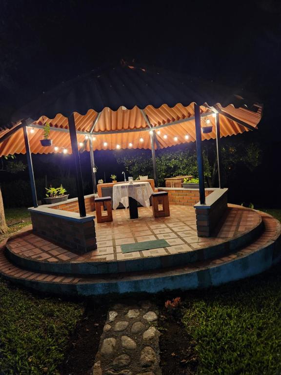 un patio con tavolo sotto una tenda di notte di Finca ARES a Filandia