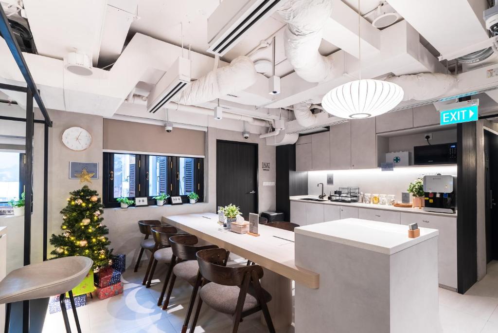 una cocina con un árbol de Navidad y una mesa larga en Jyu Capsule Hotel, en Singapur