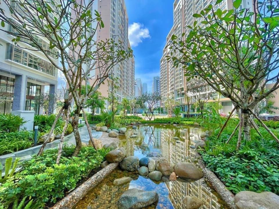 a garden with rocks and trees in a city at Convinia Luxury The Peak Midtown in Ho Chi Minh City