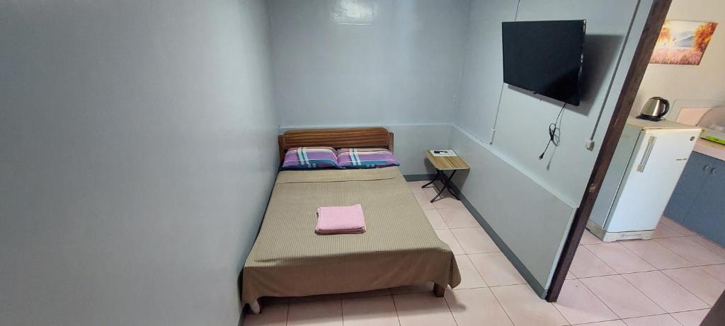 Kleines Zimmer mit einem Bett und einem TV in der Unterkunft Genna's Tourist Inn Standard Room in Pooc