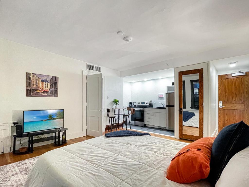 a bedroom with a bed and a flat screen tv at Quiet Studio On Grand - Downtown Dsm! in Des Moines