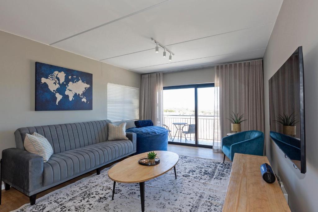 a living room with a couch and a table at Nivica 46 Luxury Apartment Langebaan in Langebaan