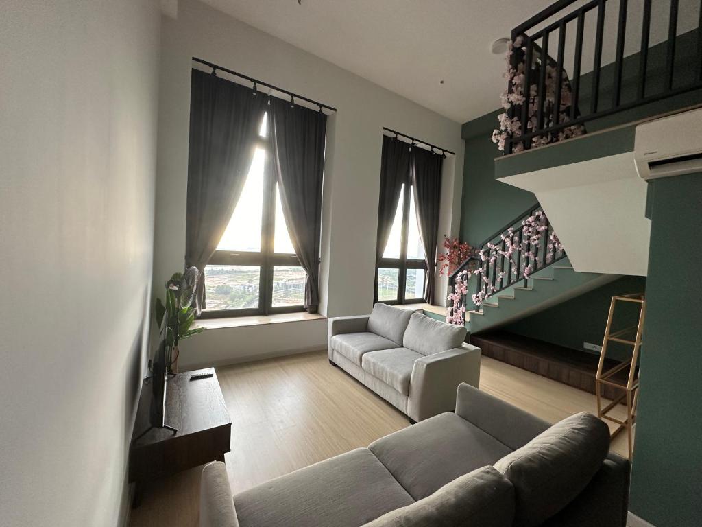 a living room with a couch and a staircase at Iskandar Puteri Sunway Grid Residence Deluxe Loft by Ningle Loft in Kampong Pendas