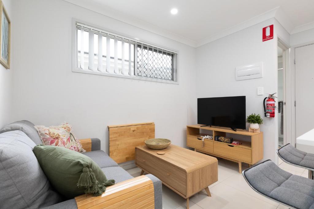 a living room with a couch and a tv at New Listing! Air-Con and Well Presented! in Brisbane