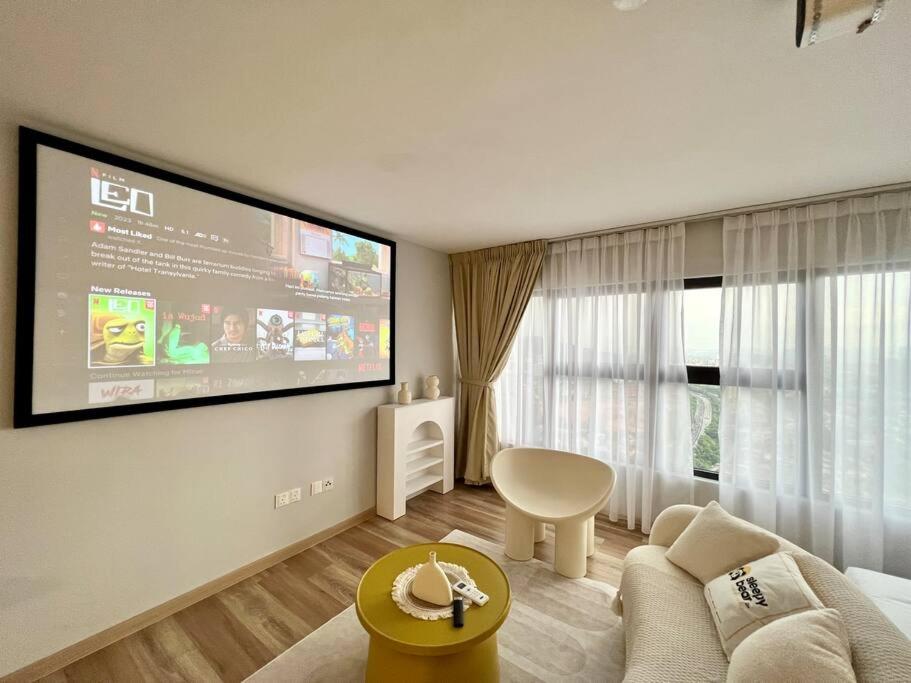 uma sala de estar com um grande ecrã na parede em Arte Cheras by Sleepy Bear em Kuala Lumpur