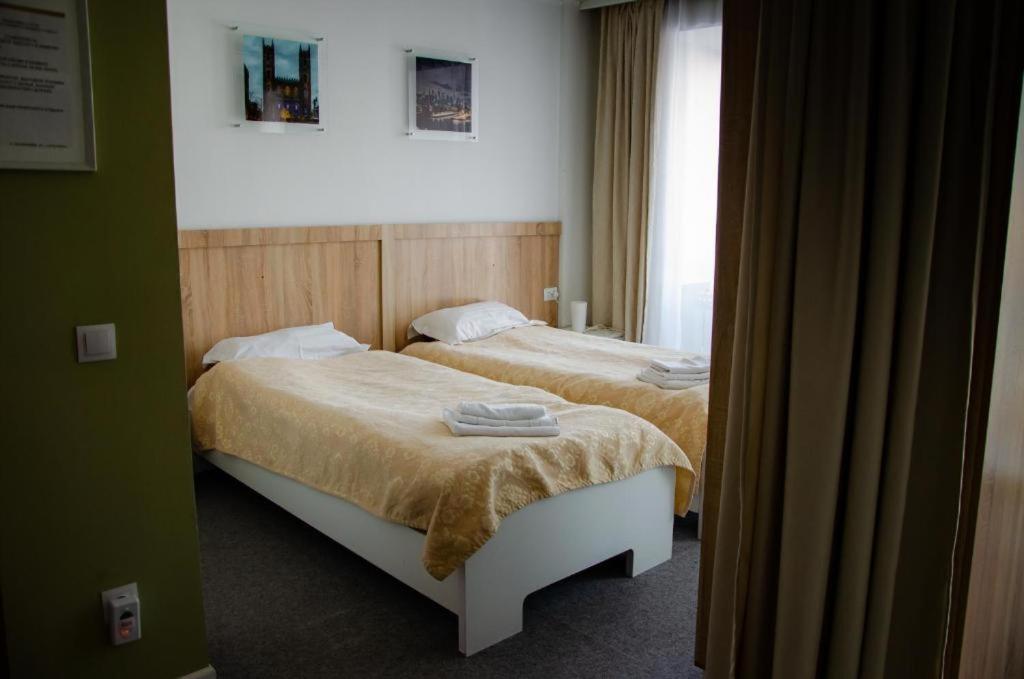a bedroom with two beds and a window at Tumar Apart Hotel in Karagandy