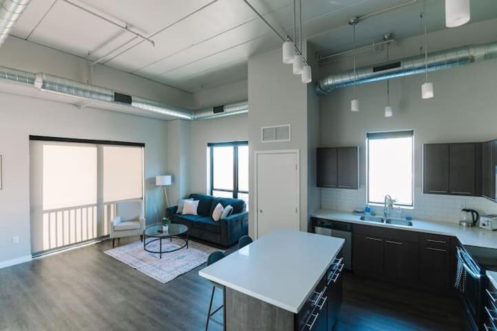 a large living room with a couch and a kitchen at 2br Skyline Apt With Panoramic Views Downtown in Des Moines