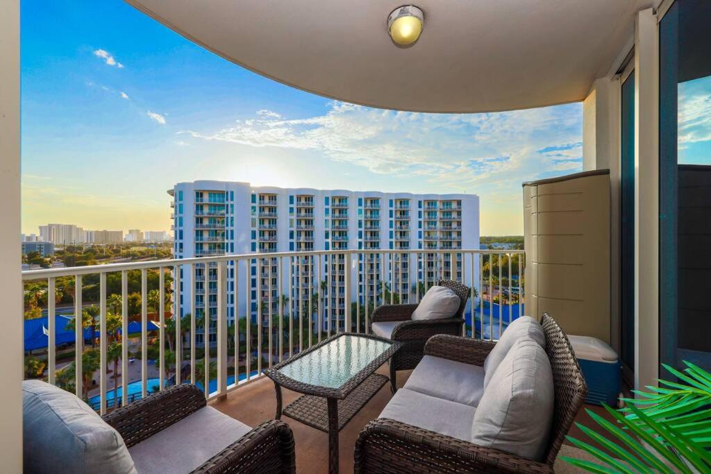 einen Balkon mit Sofas und Blick auf ein Gebäude in der Unterkunft Marvelous 9th Floor Condo Gulf, Pool &amp; Sunset View in Destin