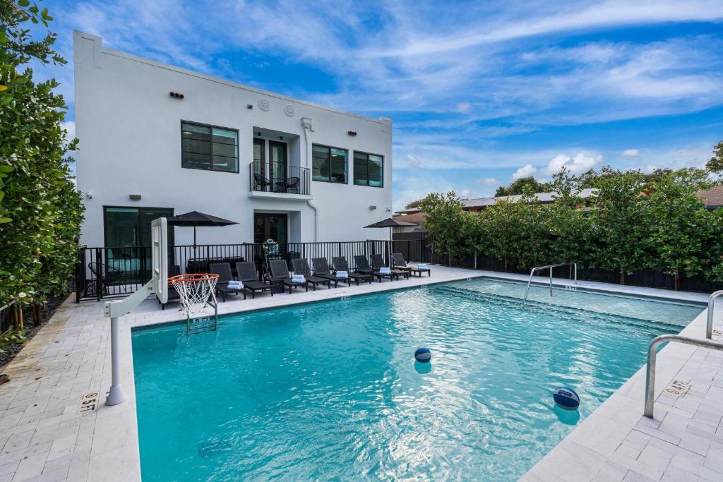 a swimming pool in front of a house at Lux Retreat By Renzzi in Miami