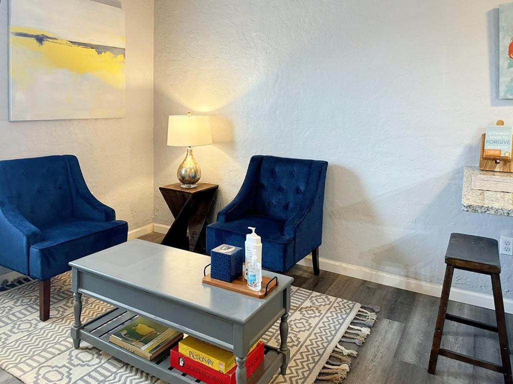 a living room with two blue chairs and a table at Cozy 1 Bedroom W Rainshower I Mins To Downtown in Oklahoma City