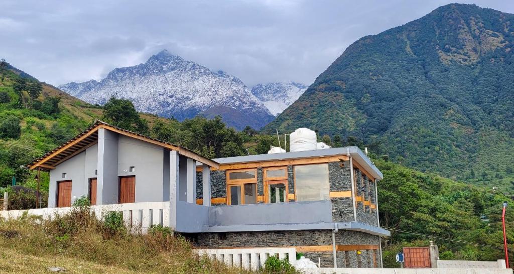 una casa su una collina con montagne sullo sfondo di Salig Hotel a Dharamshala