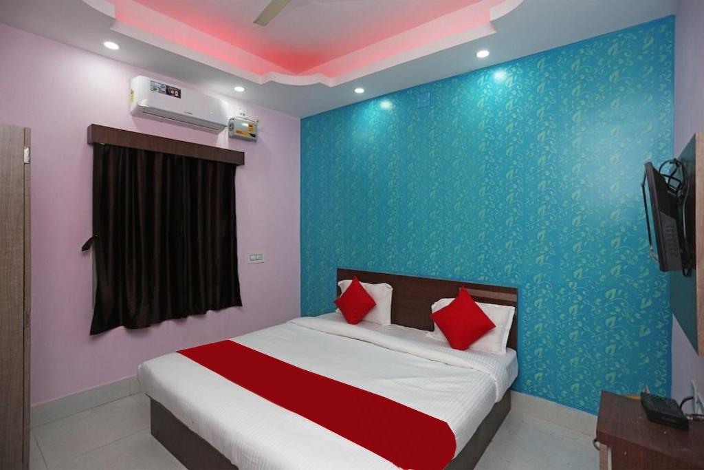 プリーにあるGoroomgo Savashi Puriのベッドルーム1室(赤い枕のベッド1台付)
