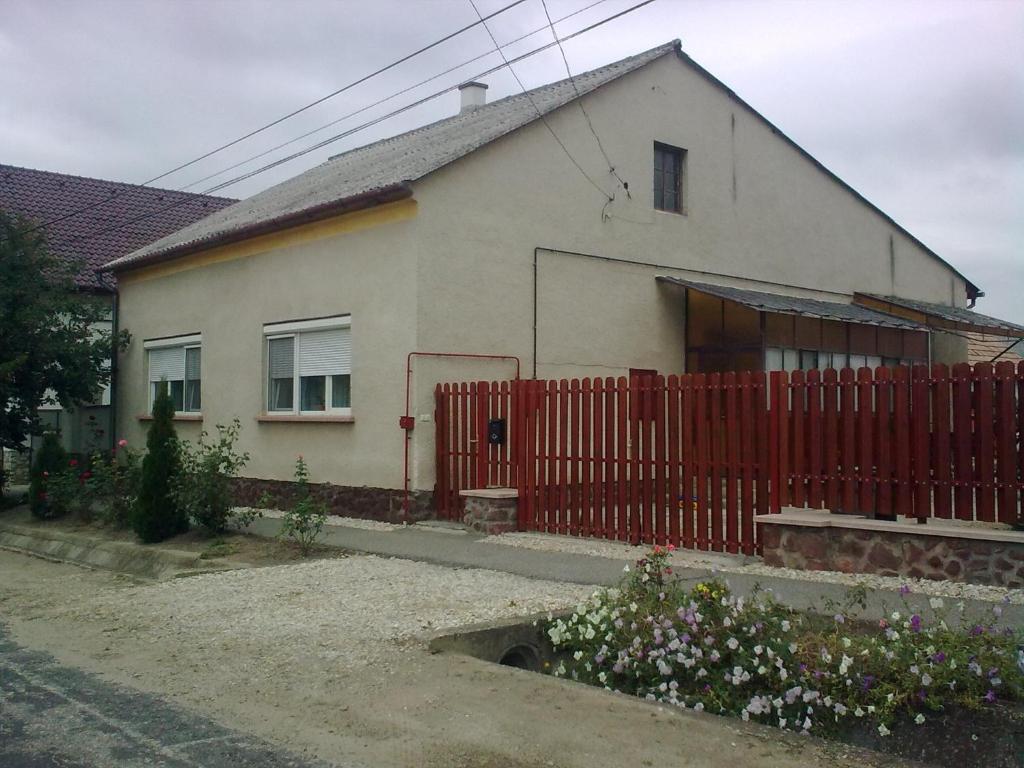 una casa con una valla roja delante de ella en Bodzavirág Vendégház en Hegykő