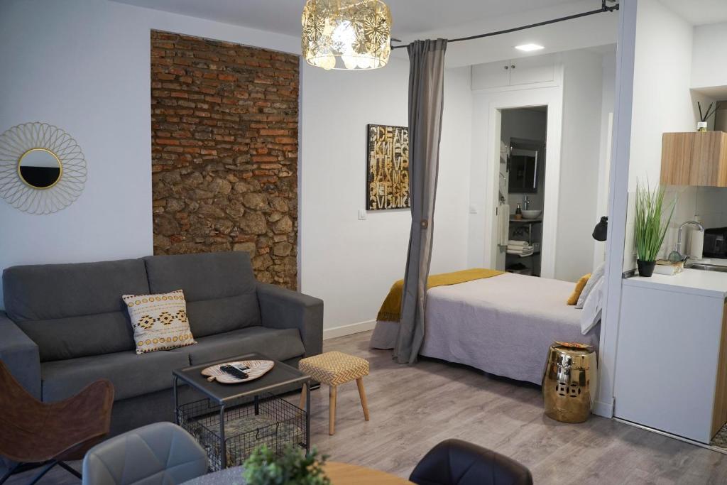 un soggiorno con divano e letto di Apartamentos Suites Cariátide a Plasencia