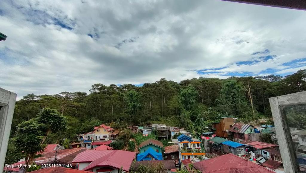 um grupo de casas em frente a uma floresta em Kochimoto Homestay em Baguio