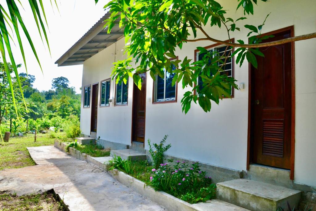 una casa bianca con una porta e dei fiori di Koh Rong Lagoon a Phumĭ Kâoh Rŏng