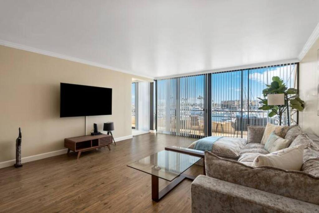 un soggiorno con divano e TV a schermo piatto di Harbor Front Haven With Stunning Marina View a Los Angeles