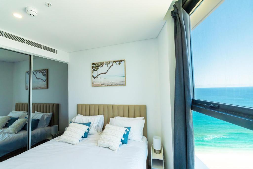 een slaapkamer met een bed en een groot raam bij In the heart of Surfers Paradise oceanview cozy 1B Apt 34F in Gold Coast