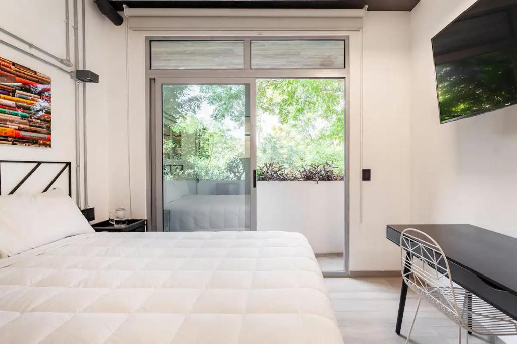 Un dormitorio con una gran cama blanca y una ventana en Mariano Escobedo 48 en Ciudad de México