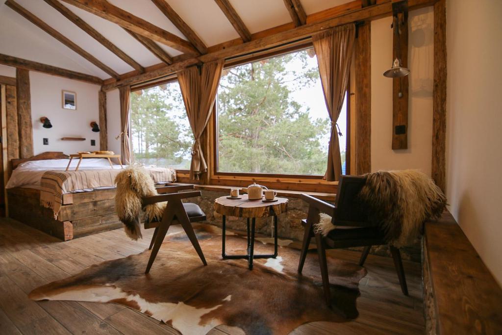 Un dormitorio con una cama, una mesa y una silla. en Rustic Cabin Zlatibor, en Ribnica
