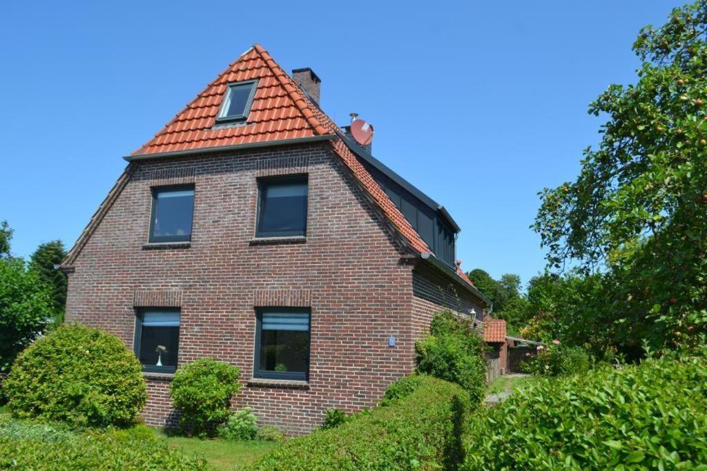 a brick house with an orange tile roof at Apart-Smutje in Stick