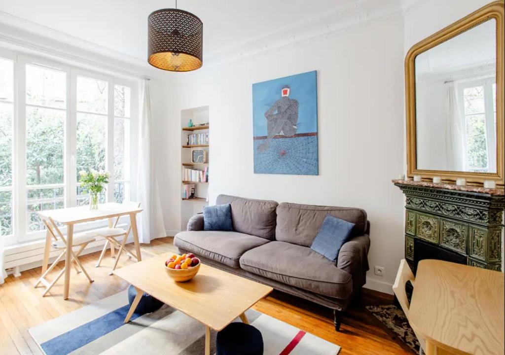 un salon avec un canapé et une table dans l'établissement Charmant appartement près du Père Lachaise, à Paris