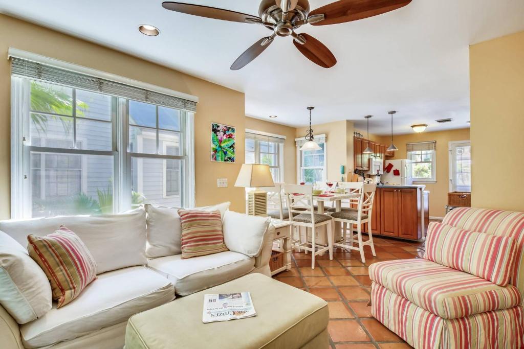a living room with a couch and a ceiling fan at Cottage by the Pool by AvantStay w Balcony BBQ Shared Pool Month Long Stays Only in Stock Island