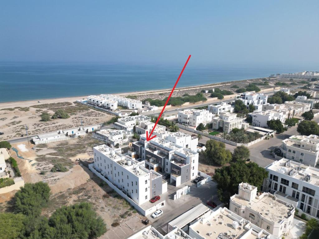 an aerial view of a white building with a red arrow at Muscat Seaside House in Muscat