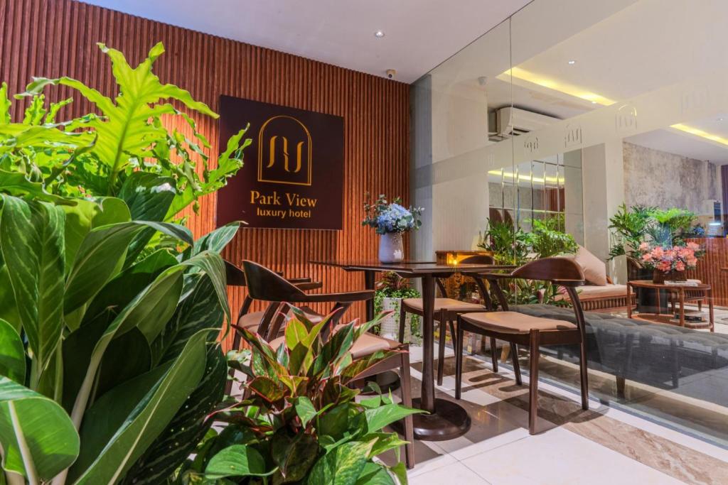 un ristorante con tavoli, sedie e piante di Park View Luxury Hotel ad Ho Chi Minh