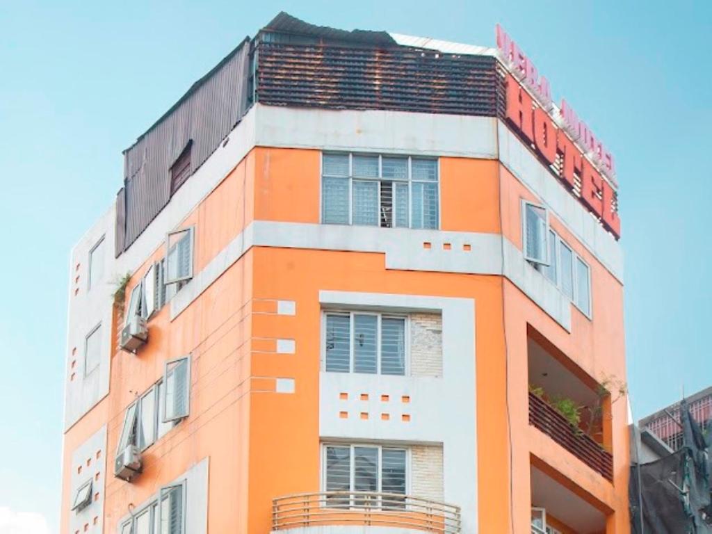 ein orangefarbenes und weißes Gebäude mit einem Schild darauf in der Unterkunft Vera Hotel Hà Nội in Hanoi