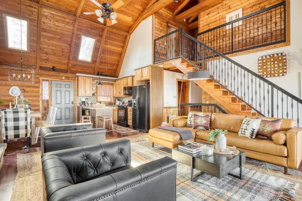 a living room with leather furniture and a wooden ceiling at Pine Needle by AvantStay Log Cabin w Gorgeous Views Hot Tub Patio Pool Table in Gatlinburg