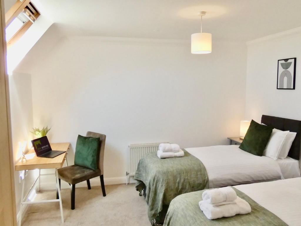 una camera con 2 letti, una scrivania e una sedia di 4 Beds 2 Bath Close To Gen-hospital Free Parking a Southampton