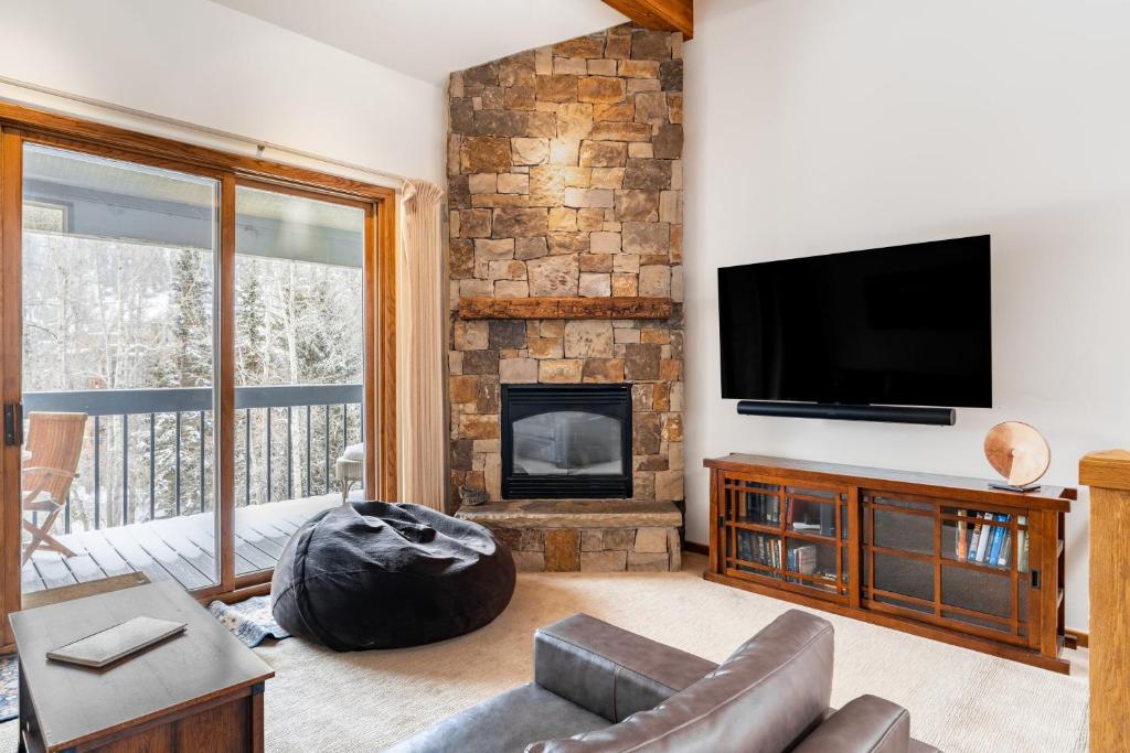 a living room with a fireplace and a television at Riverside Condos C202 by AvantStay Condo Close To Downtown Town Park Ski Lift 8 in Telluride