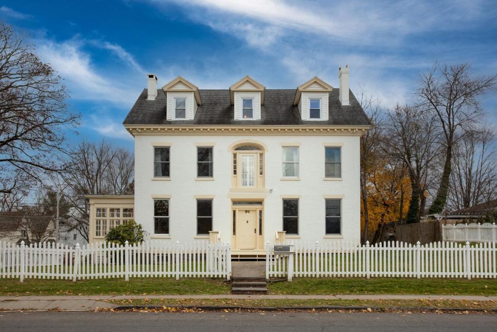 una casa blanca con una valla blanca en Hudson Estate Historic Upstate Home Private Apartment, en Saugerties