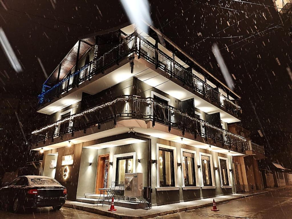 un bâtiment avec un balcon et une voiture dans la neige dans l'établissement Vila Lordev, à Korçë