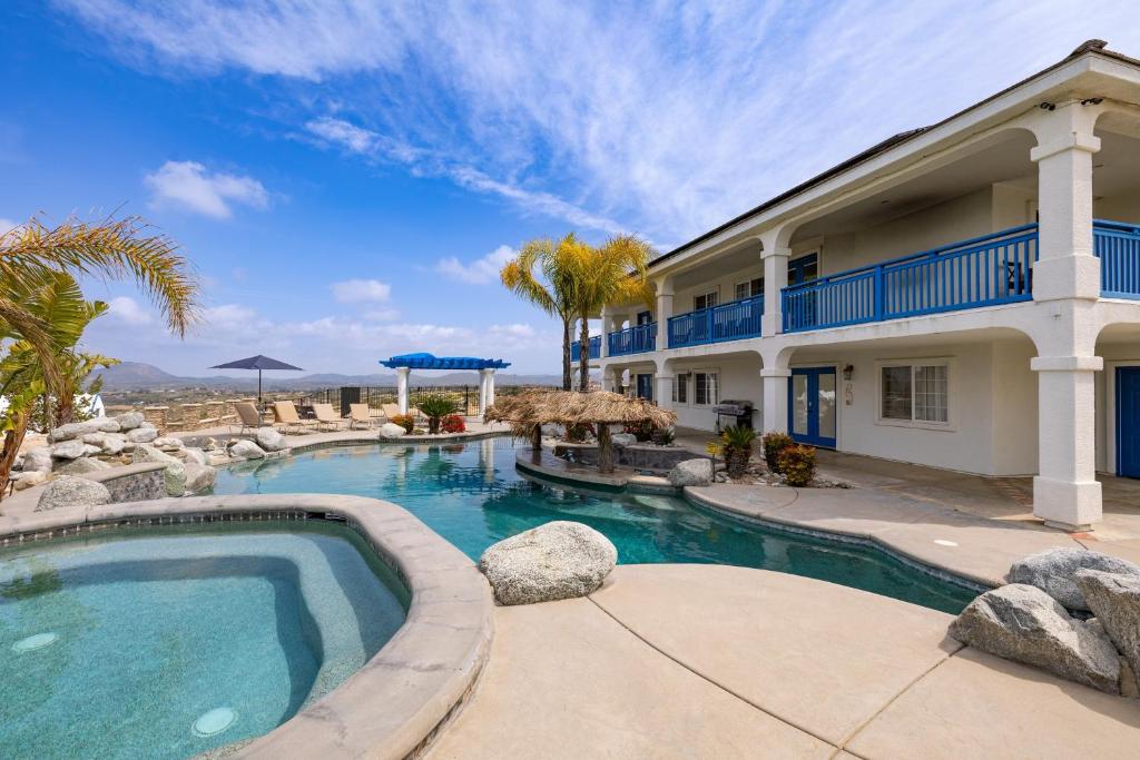 a swimming pool in front of a house at Le Grand Bleu by AvantStay Luxury Hilltop Estate in Temecula