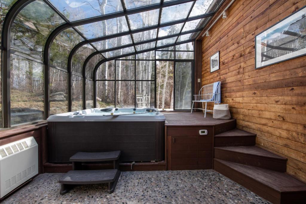 een badkamer met een bad in een glazen huis bij Condor by AvantStay Gorgeous Mountain Home w Hot Tub Sauna in Vail