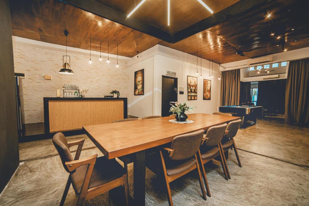 een eetkamer met een grote houten tafel en stoelen bij Modern Luxury Shoplot Style Sutera 3BR 10pax by Our Stay in Skudai