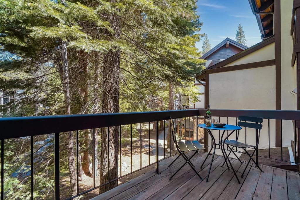 a balcony with a table and chairs and trees at Marillac by AvantStay Gorgeous Ski Cabin w Balcony Patio in Olympic Valley
